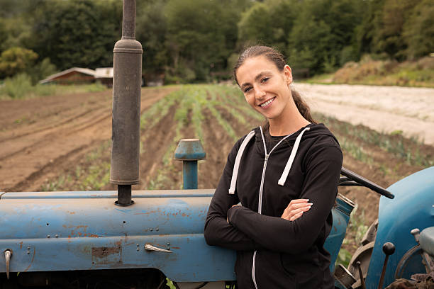 istock Confident young female farmer standing by tractor in field 2243975723