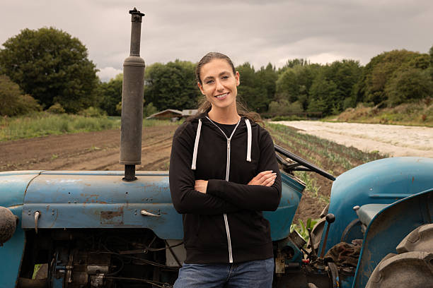 istock Confident young female farmer standing by tractor in field 2243975746