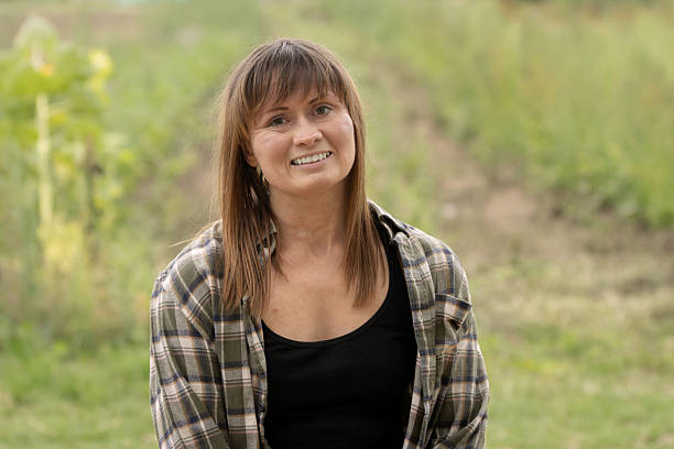 istock Happy female farm worker, sitting on a hay bale 2243976472