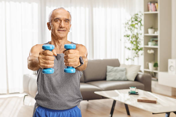 istock Elderly man in sportswear exercising with dumbbells 2243978877