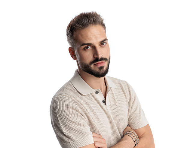 istock serious young man in polo shirt looking forward and folding arms 2243979383