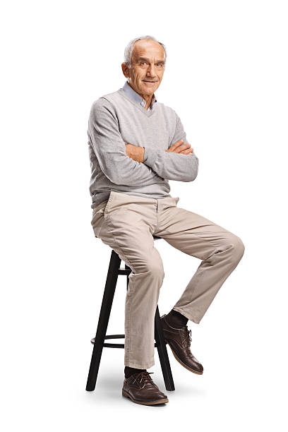 istock Smiling elderly man sitting on a chair 2243979573