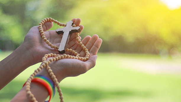 istock Wooden cross resting on open human palm 2243983750