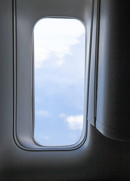 istock Looking through a big jet passenger plane window, above the clouds 2243985768