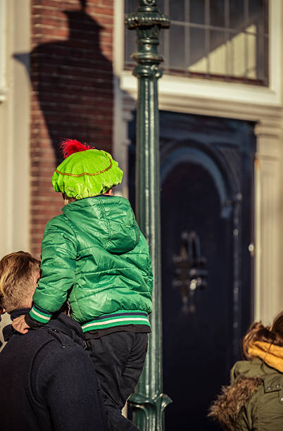 Dordrecht, Netherlands  November 17, 2018. A young child dressed in costume is carried by his father to see Saint Nicholas arrive on his white horse during the festive Sinterklaas celebration in Dordrecht.