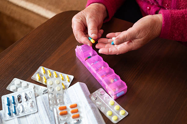 istock An elderly woman sorting pills into a daily medicine organizer 2243992537