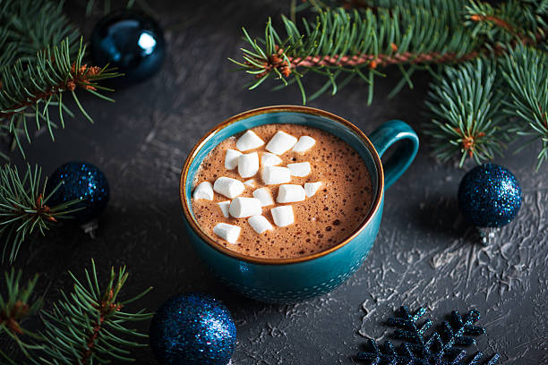 istock Hot Chocolate with Marshmallows in Teal Mug Surrounded by Christmas Decor 2243992549