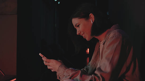istock Young woman enjoying a moment of connection while using her smartphone in a stylish setting at night 2243994477