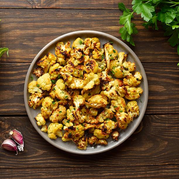 istock Roasted cauliflower on wooden background 2243994640