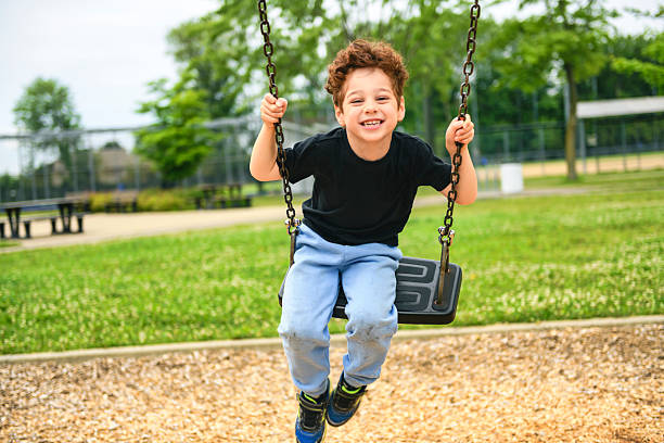 istock Happy 5 years old boy on a swing. Happy kid on playground 2243996959