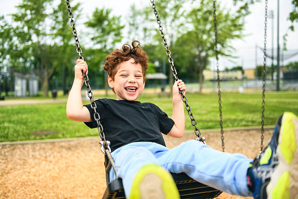 istock Happy 5 years old boy on a swing. Happy kid on playground 2243996962