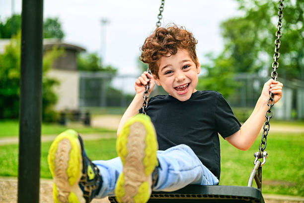 istock Happy 5 years old boy on a swing. Happy kid on playground 2243996970