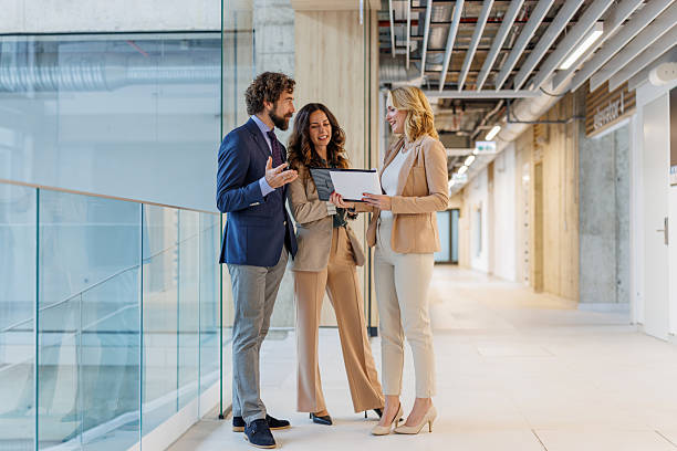 istock Business colleagues collaborating on document in office hallway 2243999235