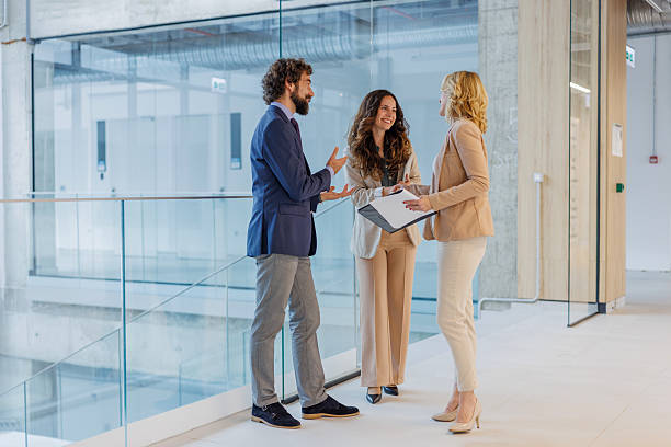 istock Business colleagues discussing project in modern office hallway 2243999358