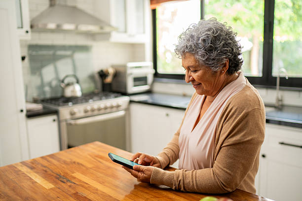 istock Senior woman using mobile phone at home 2243999439