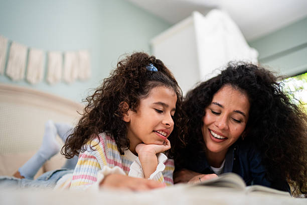 istock Mother and daughter reading book at home 2243999630