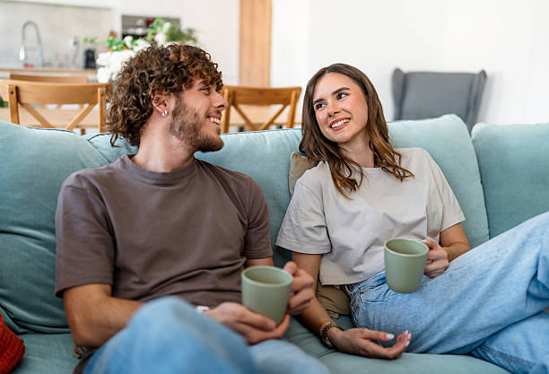 istock Young couple enjoying coffee at home talking and relaxing 2243999943