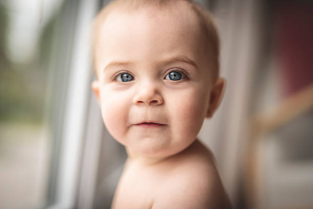 8 months old baby crawling on the floor at home.