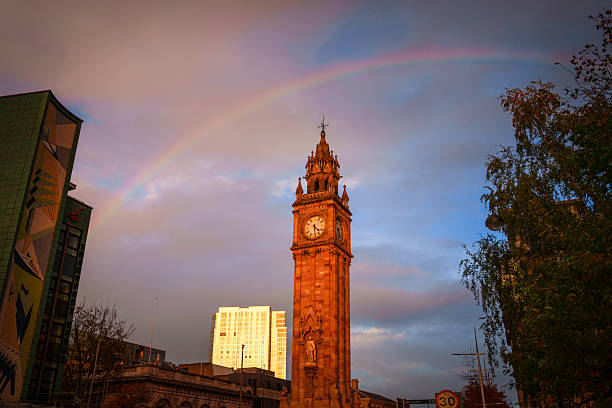 The Albert Memorial Clock, also known as the Albert Clock, stands at Queen's Square in Belfast, Northern Ireland, under a rainbow after autumn rain.