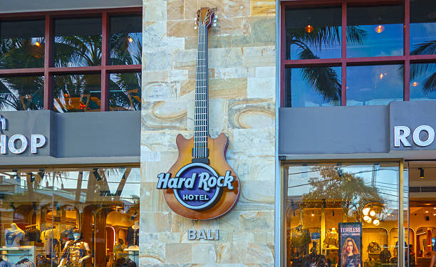Valencia, Spain - April 15, 2025: A close architectural view highlights the Hard Rock Cafe Valencia signage mounted on the exterior of a commercial building. The familiar circular logo and bold lettering identify the international restaurant chain known for music themed decor. Reflections in the glass and stone cladding frame the brand mark, placing it within a busy city center location. This photo can support content about hospitality, franchises, dining spots in Valencia, or recognizable global brands operating in Spain's urban cores.