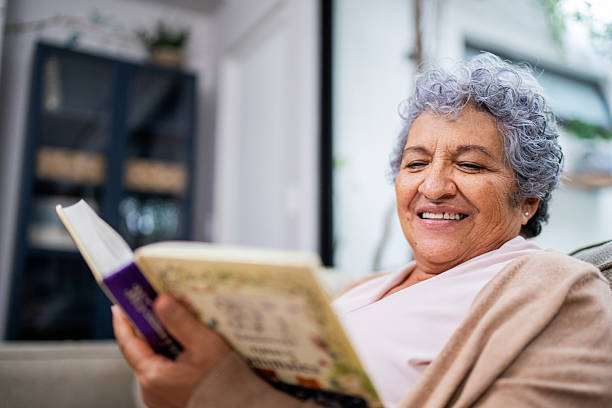 istock Senior woman reading book at home 2244001537