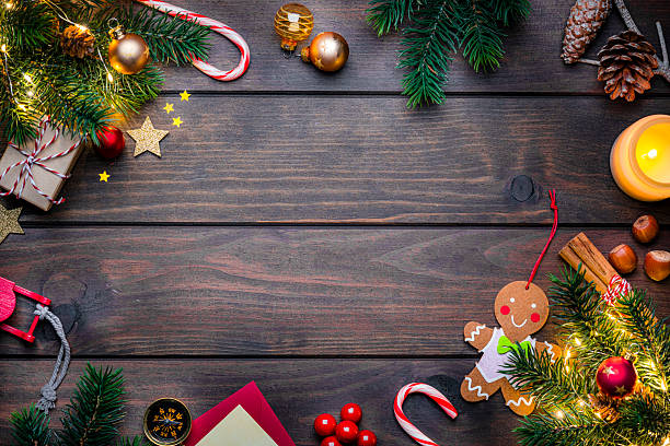 istock Christmas decoration border with copy space on wooden table. Flat lay background or Christmas card. Evening balls, lights and candle 2244001663
