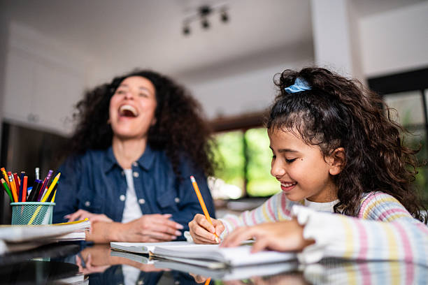 Child girl studying with mother at home
