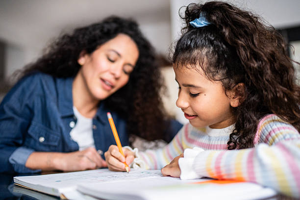 istock Child girl studying with mother at home 2244004363