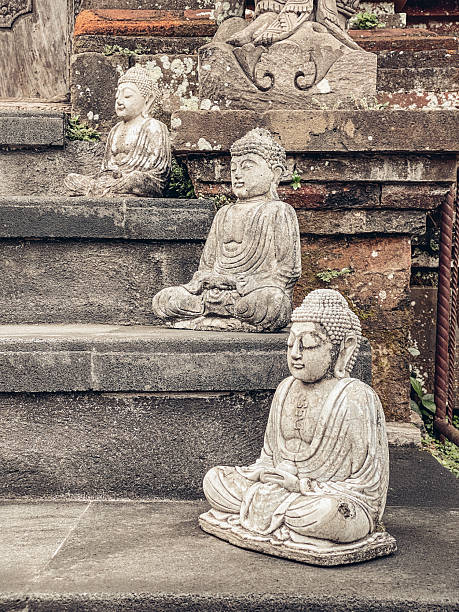 Stone statues of Buddha on the steps at the entrance to the temple. Indonesia, Bali.