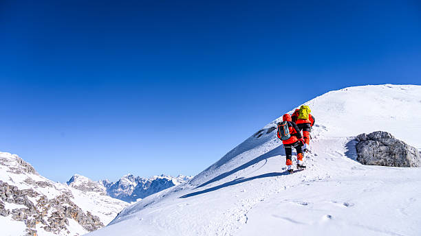 istock Climber Ascending Snowy Mountain Peak in Vibrant Gear 2244007708