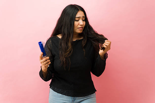istock Latin woman experiencing hair loss problem holding comb 2244008818