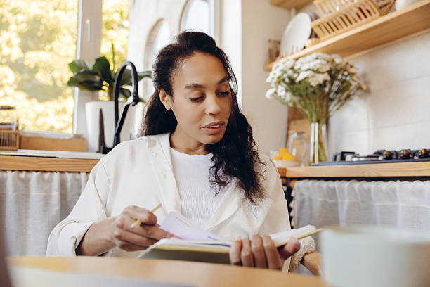 istock Beautiful African American woman businesswoman taking notes, analyzing graphs working remote at home 2244013018