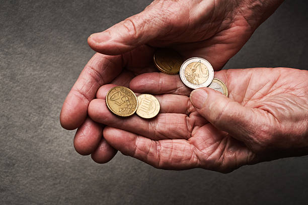 istock Hands of an elderly person with coins. 2244013343