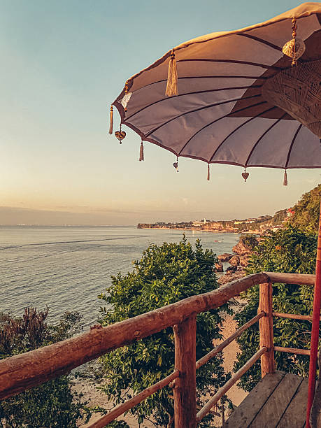 istock Bright white Balinese umbrella in a cafe overlooking the ocean 2244016418