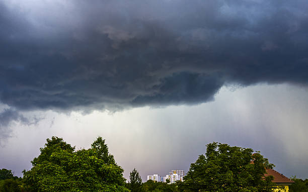 istock Dark thunderclouds over green trees in the city 2244018249