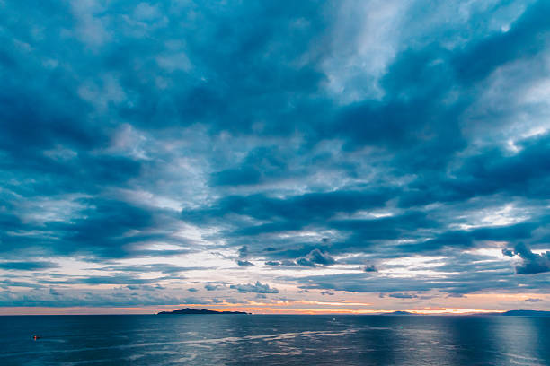 Cloudy evening sky. An island in dice, the rest only the infinity of the sky and the sea.