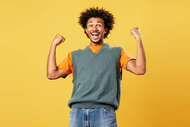 istock Smiling excited African American man having win looking at camera isolated on yellow background 2244024017