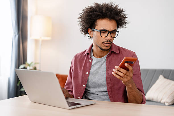 istock Serious, pensive African American man in eyeglasses holding mobile phone using mobile app 2244024067