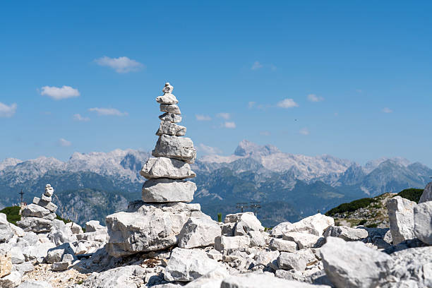 Beautiful mountain range of Julian Alps with mount Triglav, view from the Vogel Ski resort on sunny day, in front view stack of stones, rocks Slovenia.