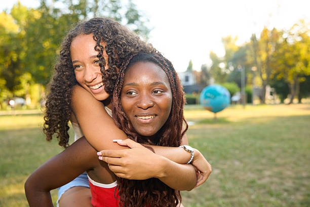istock Two Friends Enjoying a Sunny Day in a Park Together 2244027497