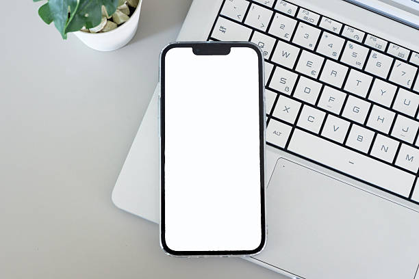 istock Smartphone with blank white screen on laptop over gray desk 2244039276