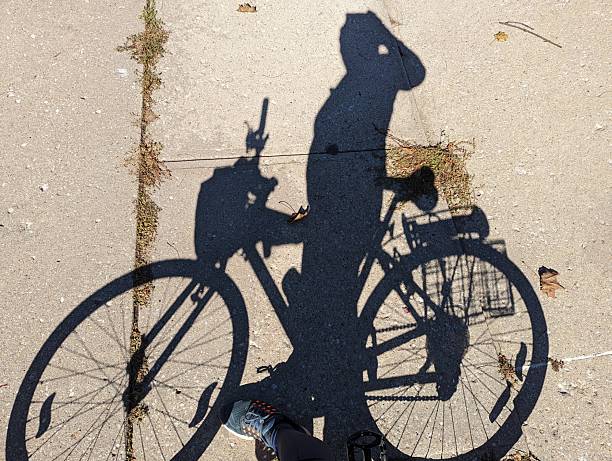A shadow of a cyclist on the street, with a rack that is ready to hold stops around town in this Eco-friendly set up.
