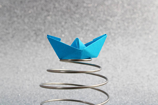 istock Paper boat floats on a spiral, overcoming difficulties 2244046248