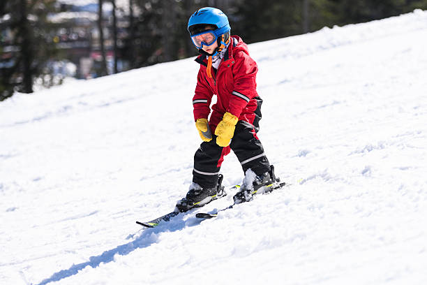istock Young boy learning skiing on a snowy mountain 2244053397