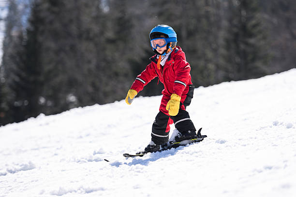 istock Child skiing down snowy mountain slope 2244053404