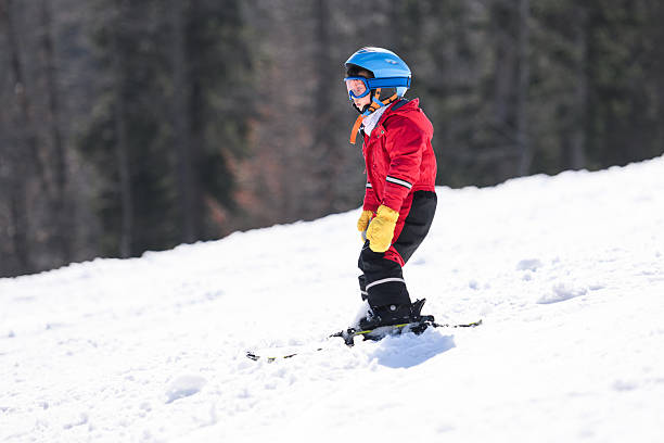 istock Young boy skiing down snowy mountain slope 2244053410