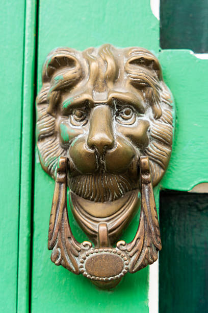 Golden lion-shaped door knocker on green front door in Venice, Italy
