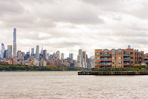 This is a photograph of the New York City skyline viewed from across the Hudson River in  Edgewater, New Jersey on an overcast, autumn day.