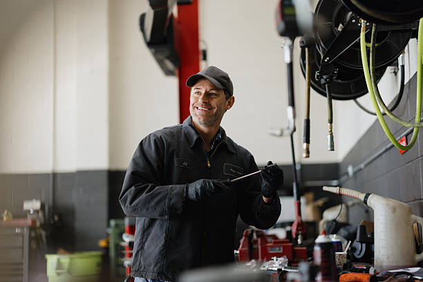 istock Mechanic Smiling and Holding a Tool in a Garage 2244059143