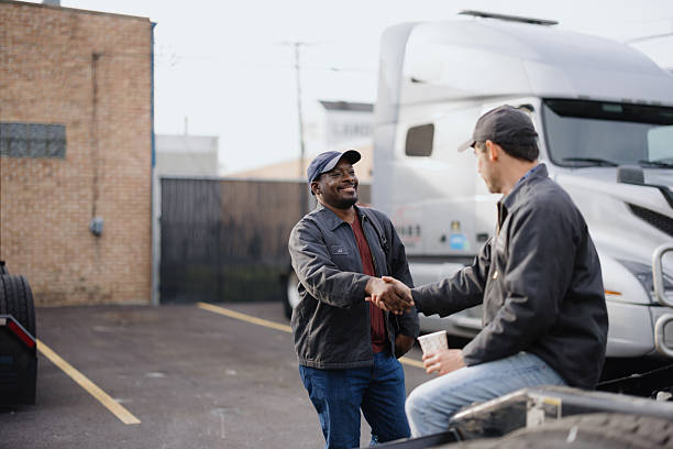 istock Two truck drivers shaking hands in a parking lot 2244059245